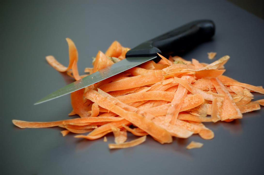 kitchen knife on top of a pile of carrot peel